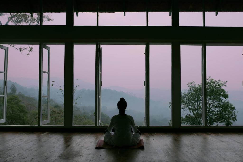 Woman practicing yoga at a luxury 5 star resort in Munnar, Kerala.