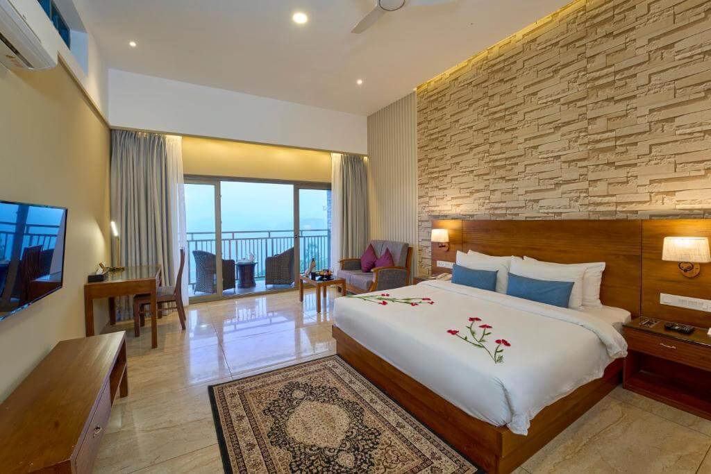 Spacious suite with a balcony at a luxury resort in Munnar.
