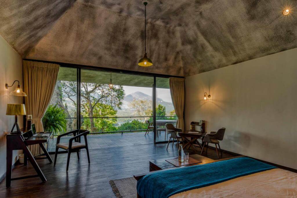 Elegant bedroom with a private garden at a luxury resort in Munnar.