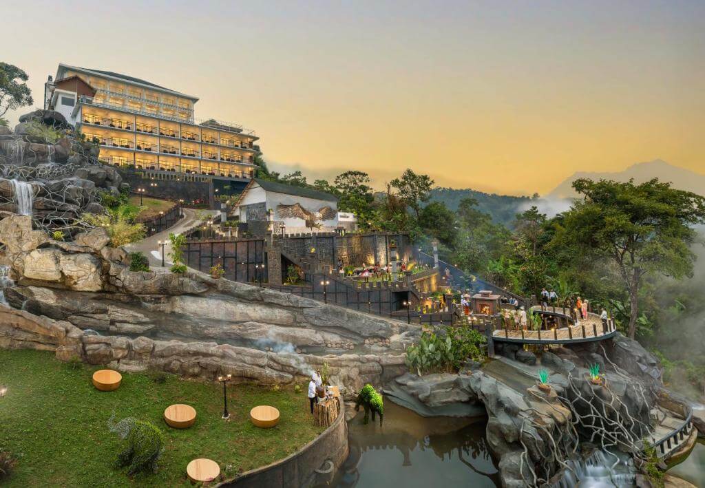 Aerial view of a 5-star hotel nestled in the lush green hills of Munnar.