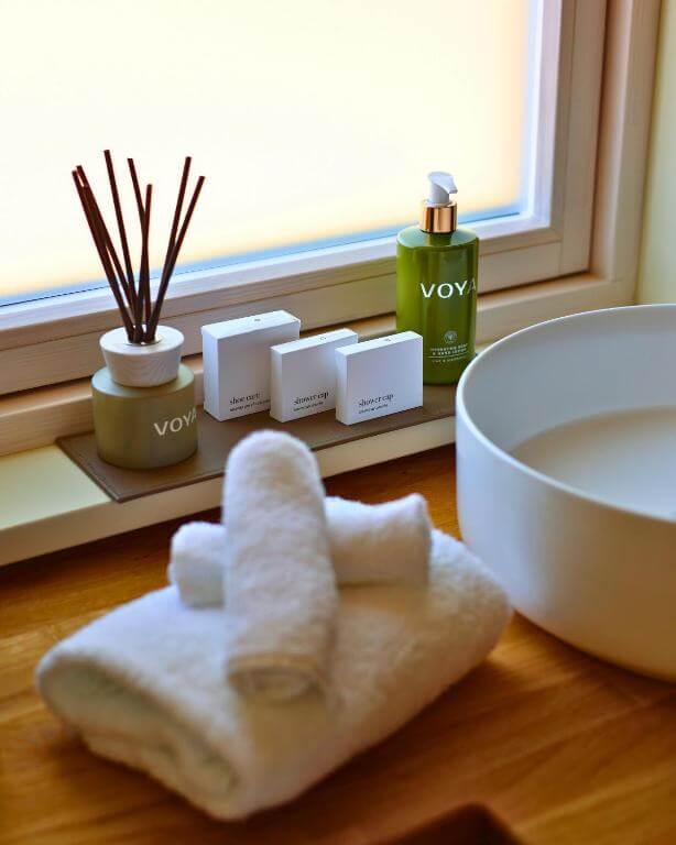 Freestanding stone basin and backlit mirror in the bathroom of a Ballygarry Estate luxury cabin in Ireland.