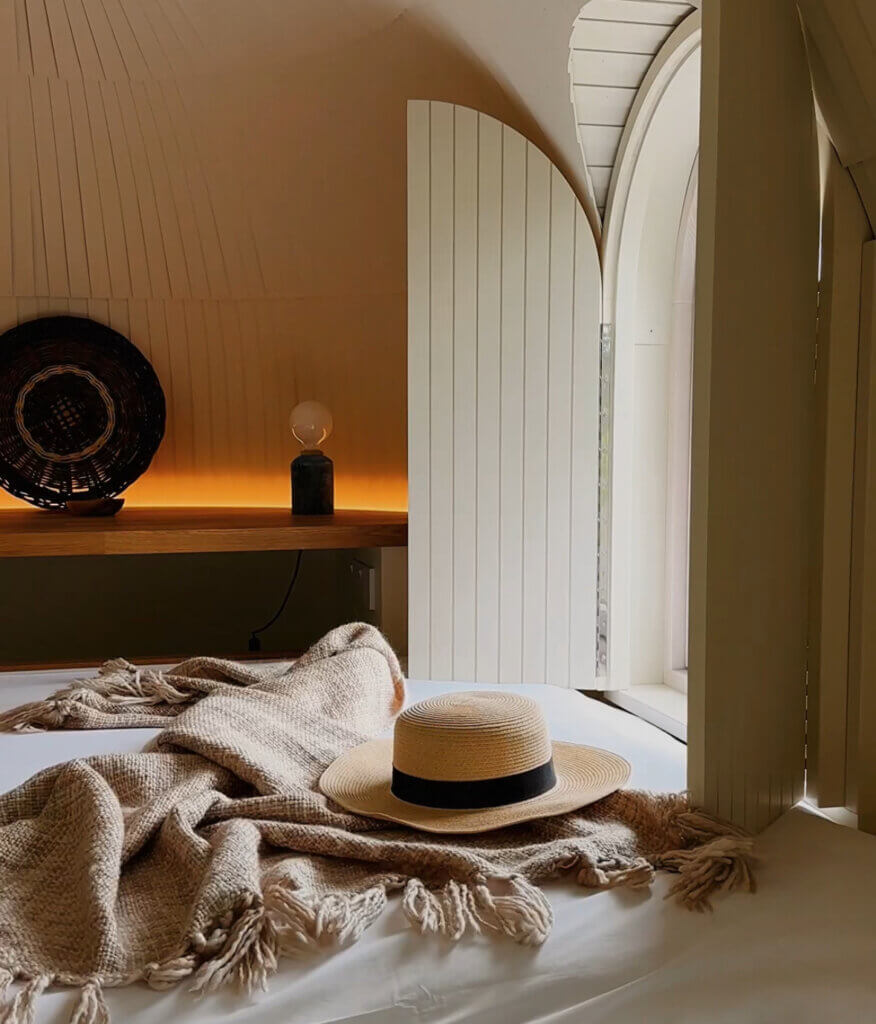 A straw hat and a blanket lie on a bed in one of Ireland's newest luxury cabins at Ballygarry Estate.