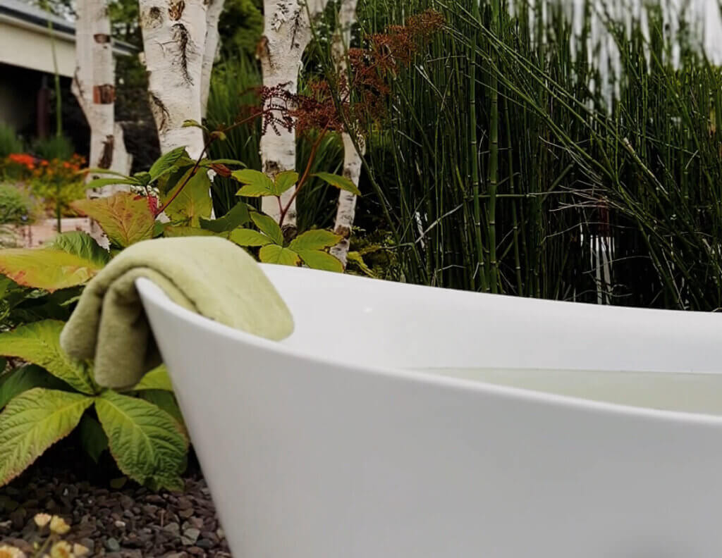 VOYA skincare products beside the bath during a relaxing spa experience at a luxury cabin in Ireland.