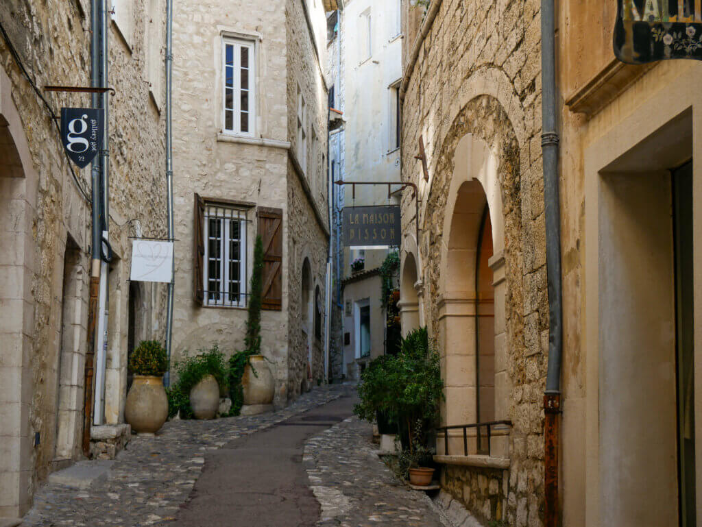 Cobbled street in Saint Paul de Vence with stone houses and flowers