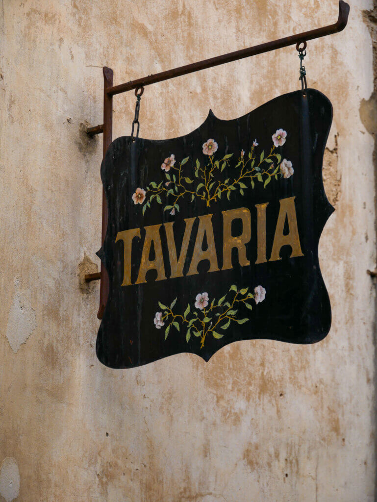 Shop sign decorated by flowers on a shop in Saint Paul de Vence.