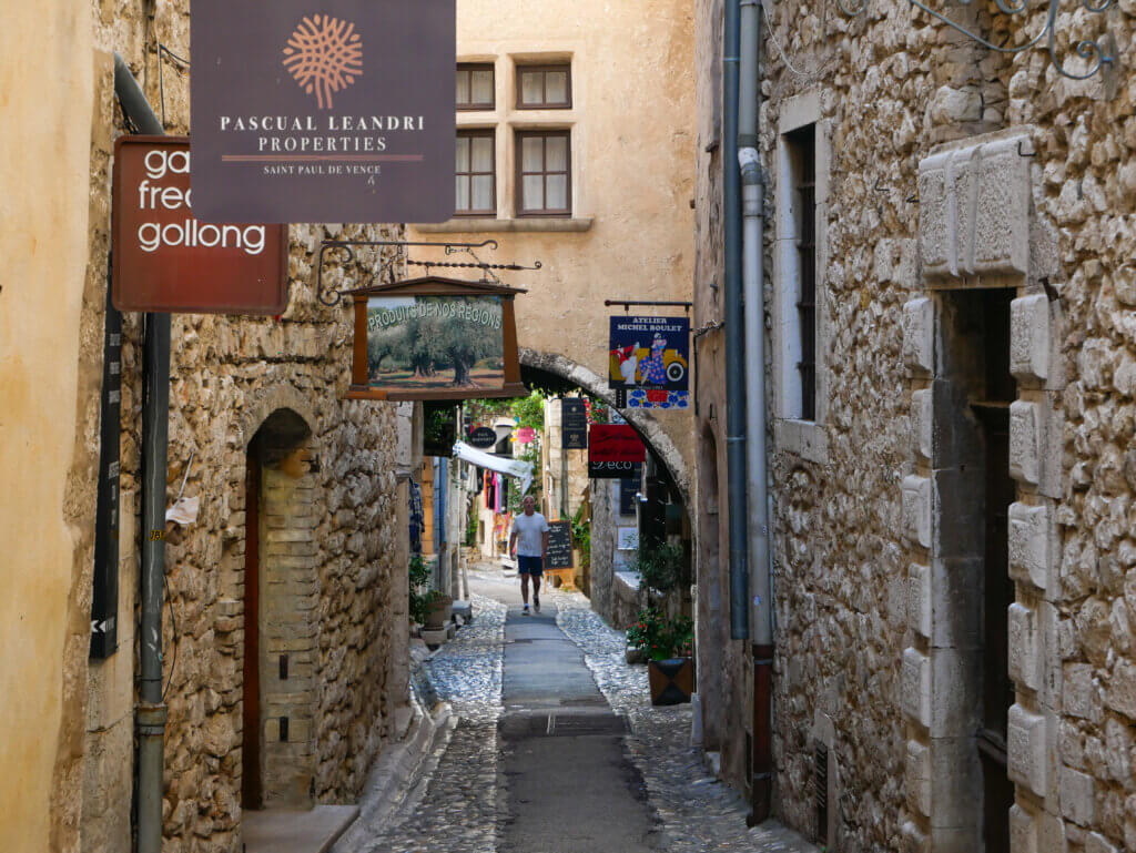 Tourist walking through cobbled streets of Saint Paul de Vence