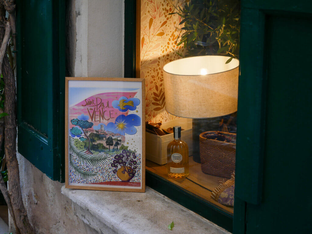 Shop window, showing a piece of art, a perfume bottle, and a lamp in the medieval village of Saint Paul de Vence.