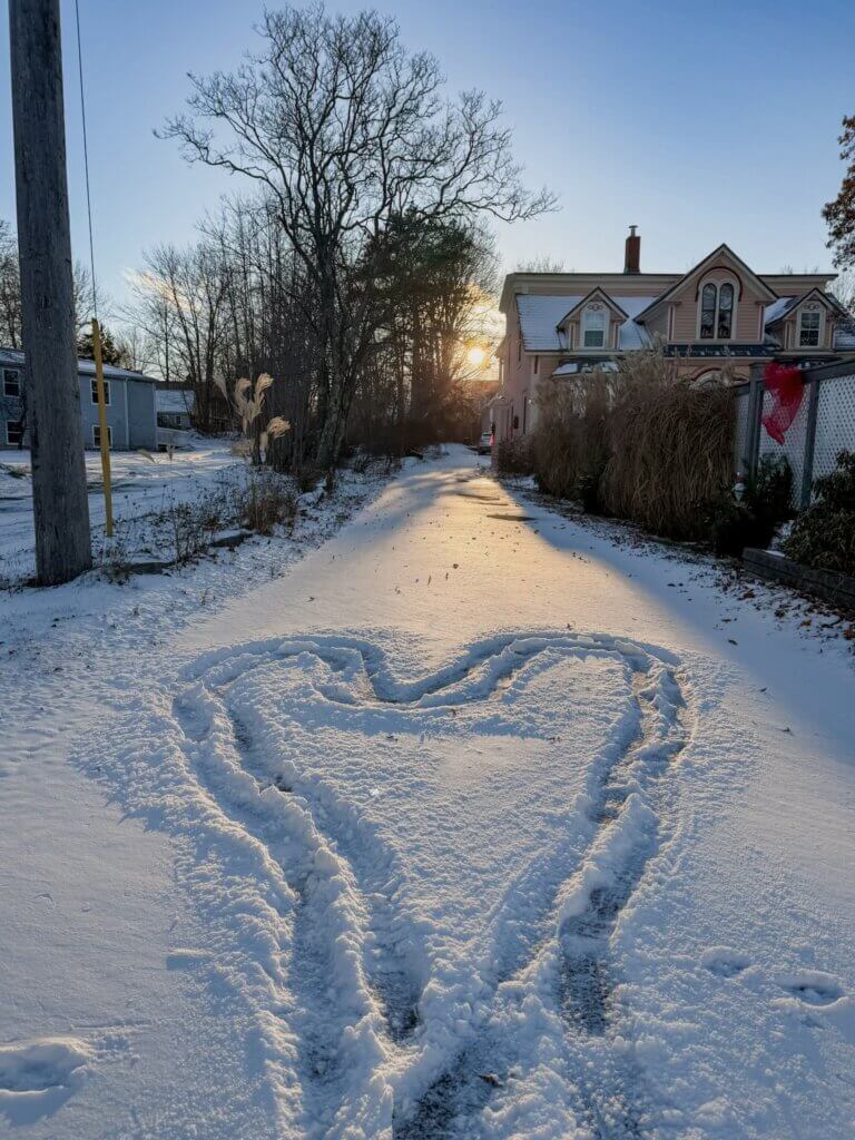 Heart drawn in the snow at sunset at Mahone Bay, a coastal village in Nova Scotia.