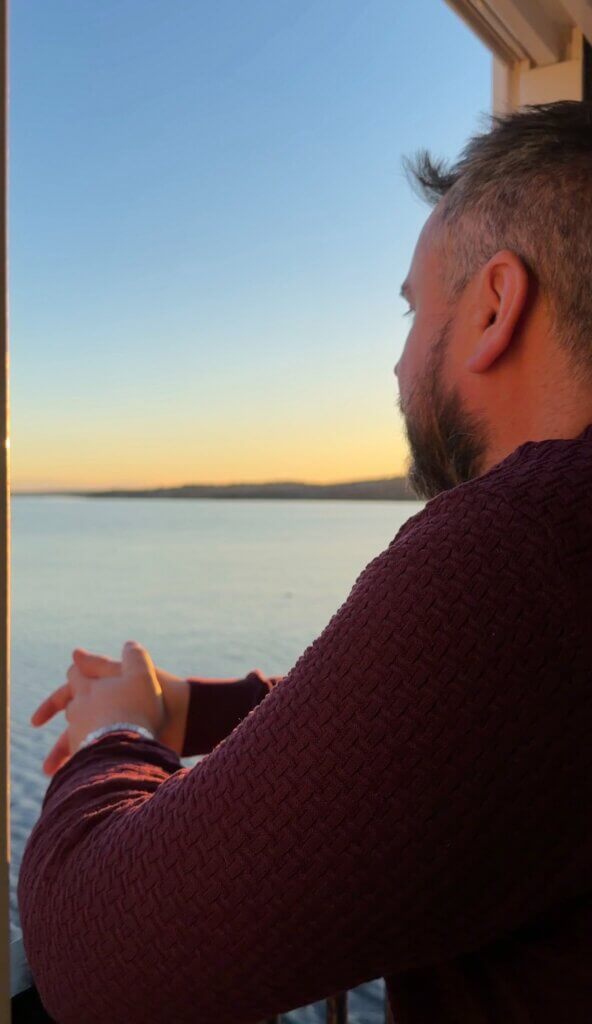 Man looking out at Shelburne harbour at sunset.