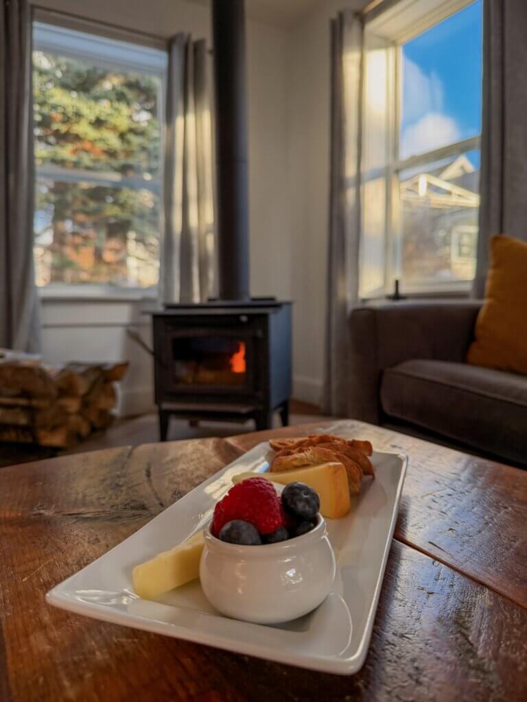 Fruit and cheese platter sitting on a table in front of a woodburning stove at Oceanstone Resort in Nova Scotia