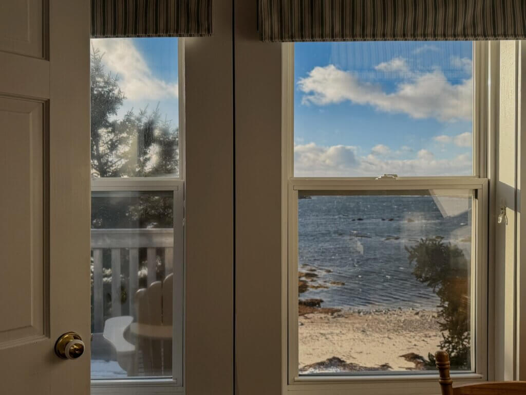 Window framing a beach and ocean view